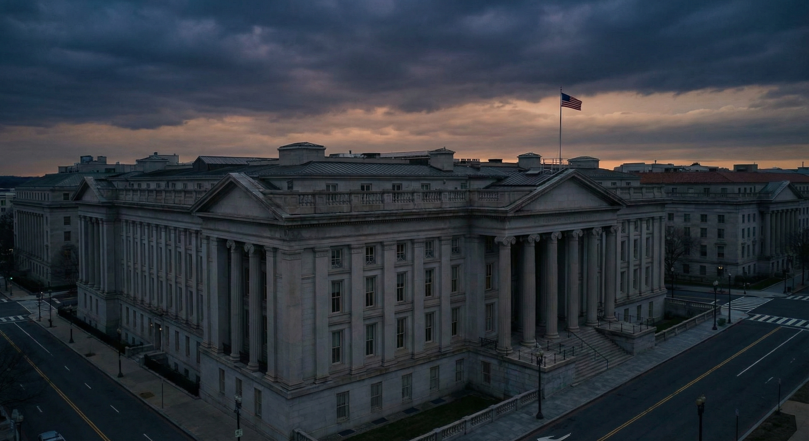 Aerial view of the U.S. Treasury building in Washington D.C. at dawn, neoclassical architecture with columns and American flag, dark moody sky